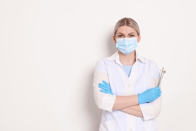 Photo of Professional dentist with tools on white background. Space for text