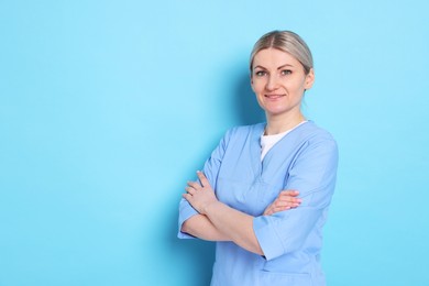 Photo of Portrait of professional dentist on light blue background. Space for text