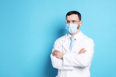 Portrait of professional dentist on light blue background. Space for text