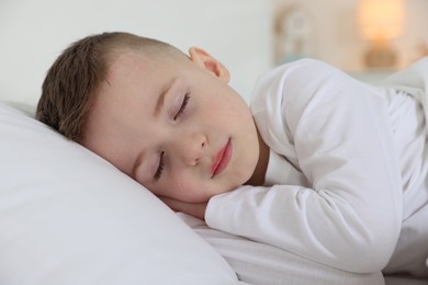 Photo of Bedtime. Cute boy sleeping in comfortable bed