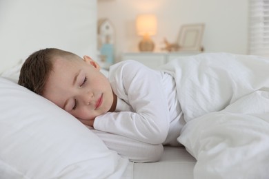 Photo of Bedtime. Cute boy sleeping in comfortable bed