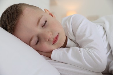 Photo of Bedtime. Cute boy sleeping in comfortable bed