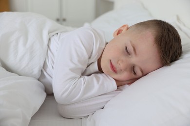 Photo of Bedtime. Cute boy sleeping in comfortable bed