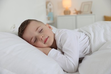 Photo of Bedtime. Cute boy sleeping in comfortable bed