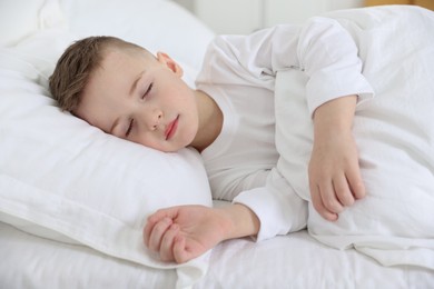 Photo of Bedtime. Cute boy sleeping in comfortable bed