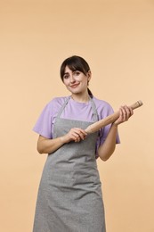 Photo of Woman with rolling pin on beige background