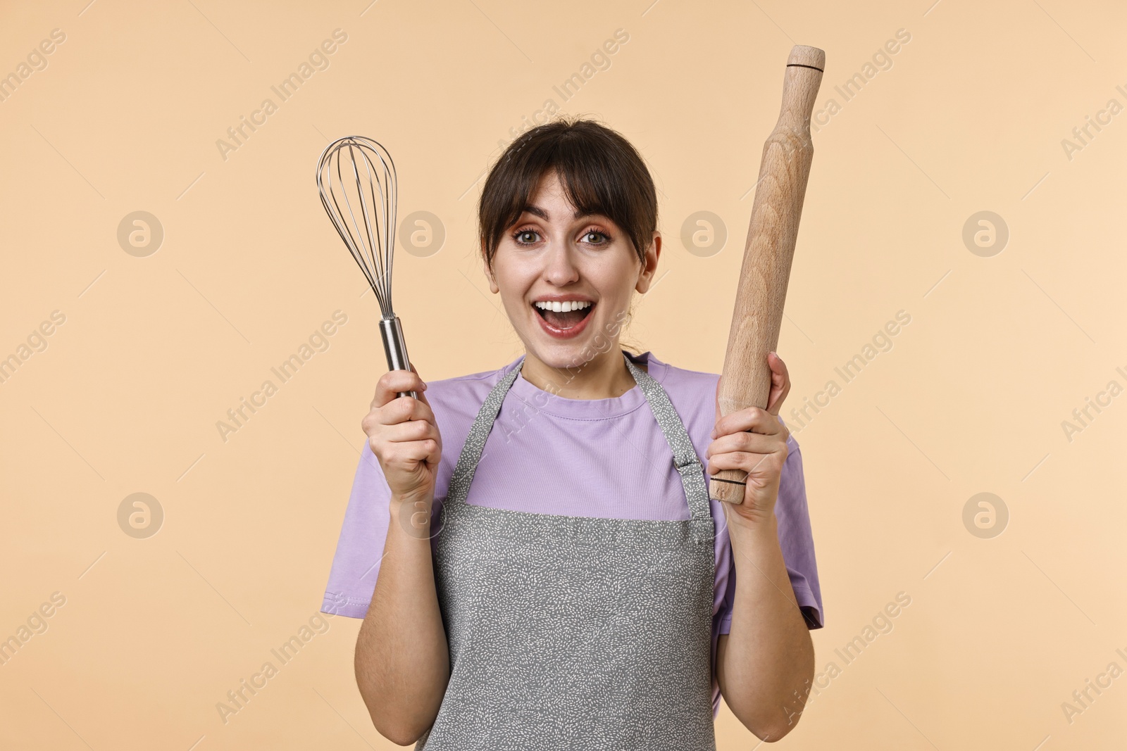 Photo of Woman with rolling pin and whisk on beige background