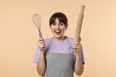 Woman with rolling pin and whisk on beige background