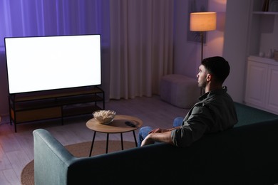 Man watching tv at home in evening