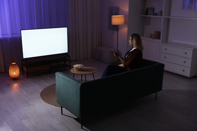 Woman watching tv at home in evening