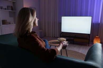 Woman watching tv at home in evening