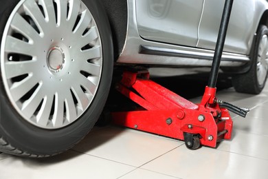 Photo of Car lifted by scissor jack at service station