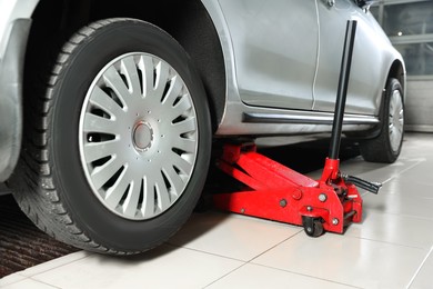 Photo of Car lifted by scissor jack at service station