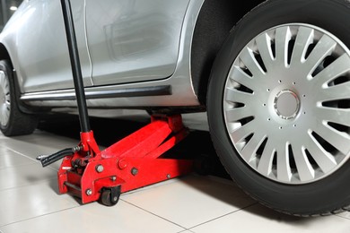 Photo of Car lifted by scissor jack at service station