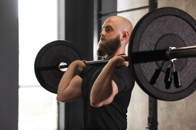 Photo of Sportsman with barbell during crossfit workout in gym