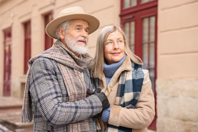 Photo of Lovely elderly couple holding hands on city street