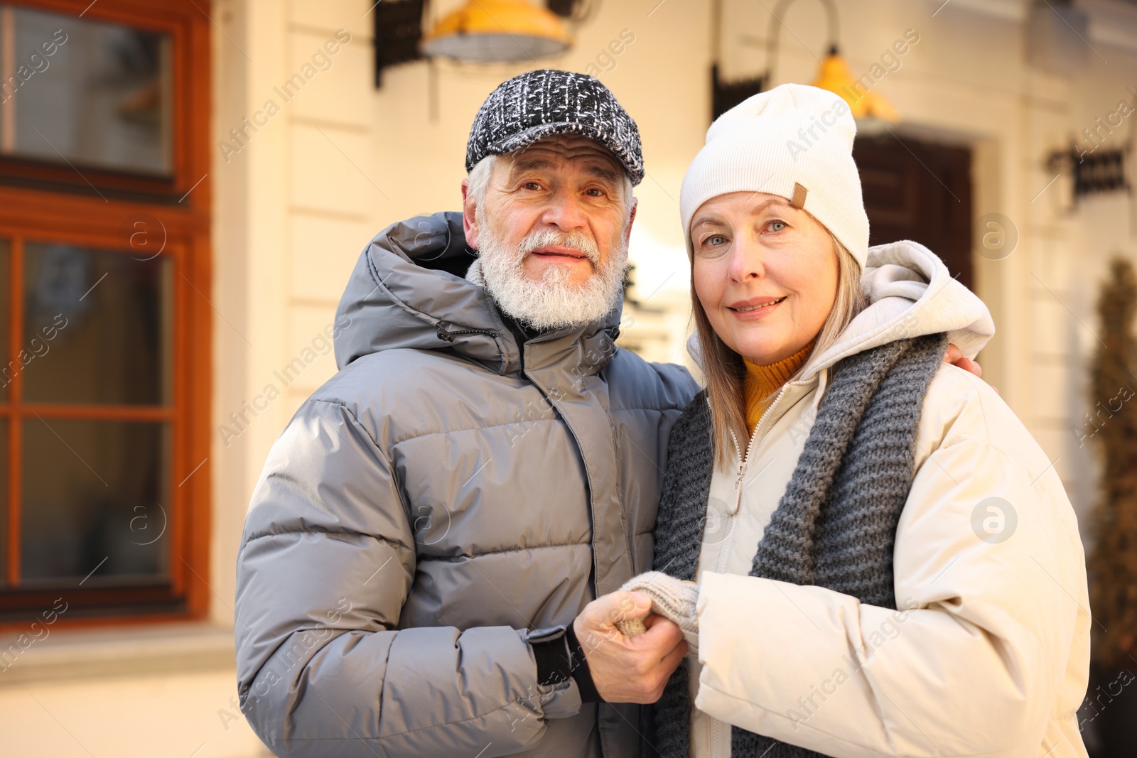 Photo of Happy elderly couple holding hands on city street