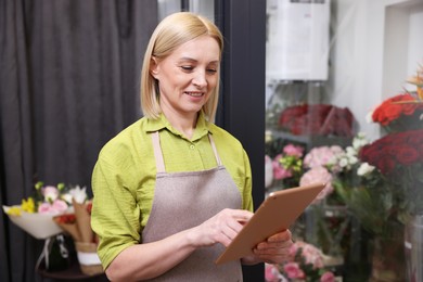 Photo of Business owner with tablet in her flower shop