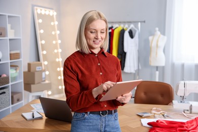 Photo of Business owner with tablet in her tailor shop