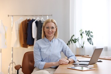 Photo of Business owner at table in her tailor shop