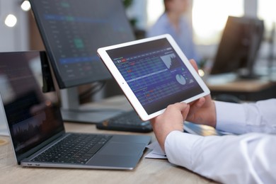 Stock exchange. Man working at desk in office, closeup