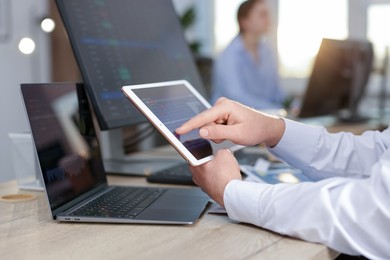 Stock exchange. Man working at desk in office, closeup