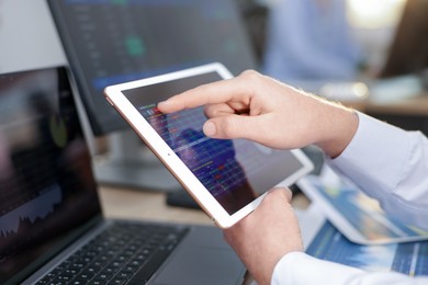 Stock exchange. Man working at desk in office, closeup