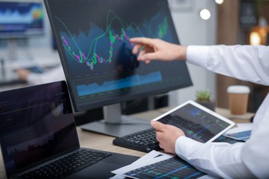 Stock exchange. Man working at desk in office, closeup