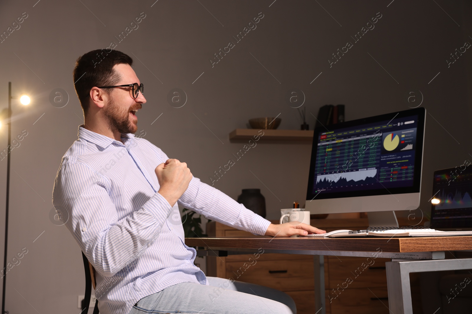 Photo of Stock exchange. Man analysing financial market on computer at desk indoors