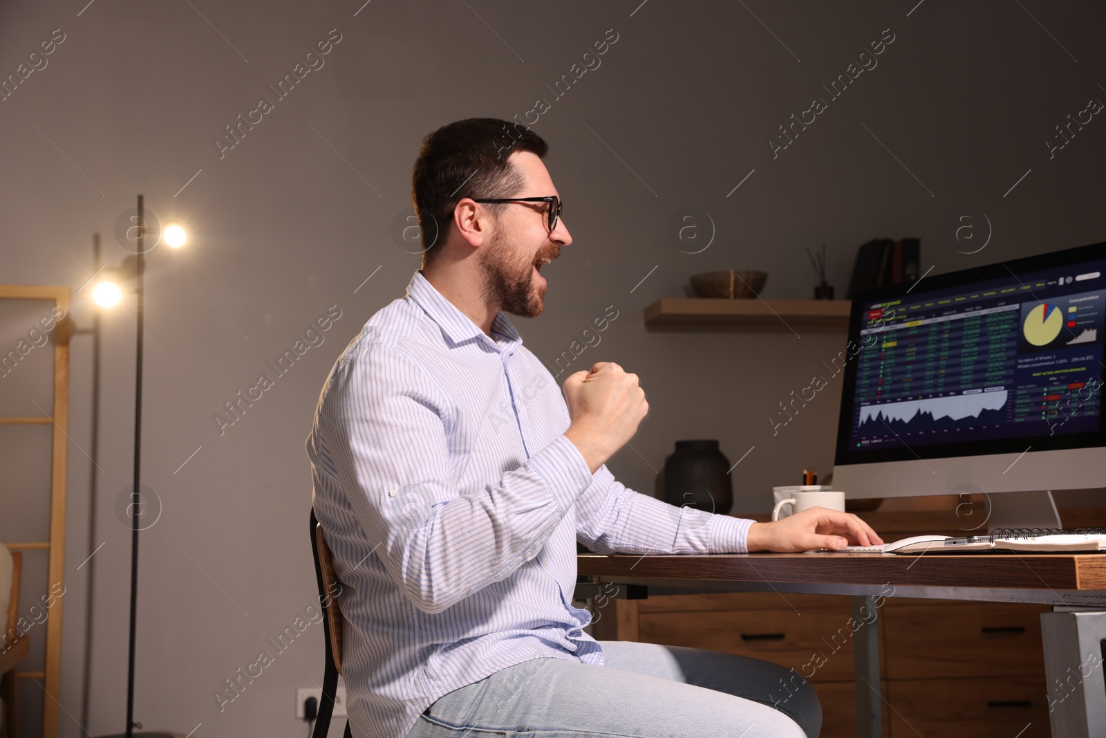 Photo of Stock exchange. Man analysing financial market on computer at desk indoors