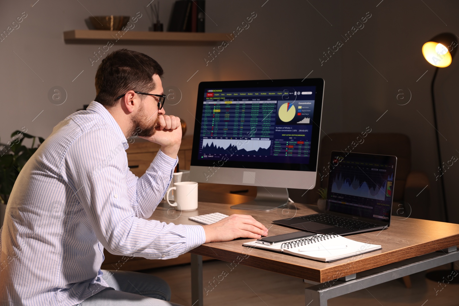 Photo of Stock exchange. Man analysing financial market on computer at desk indoors