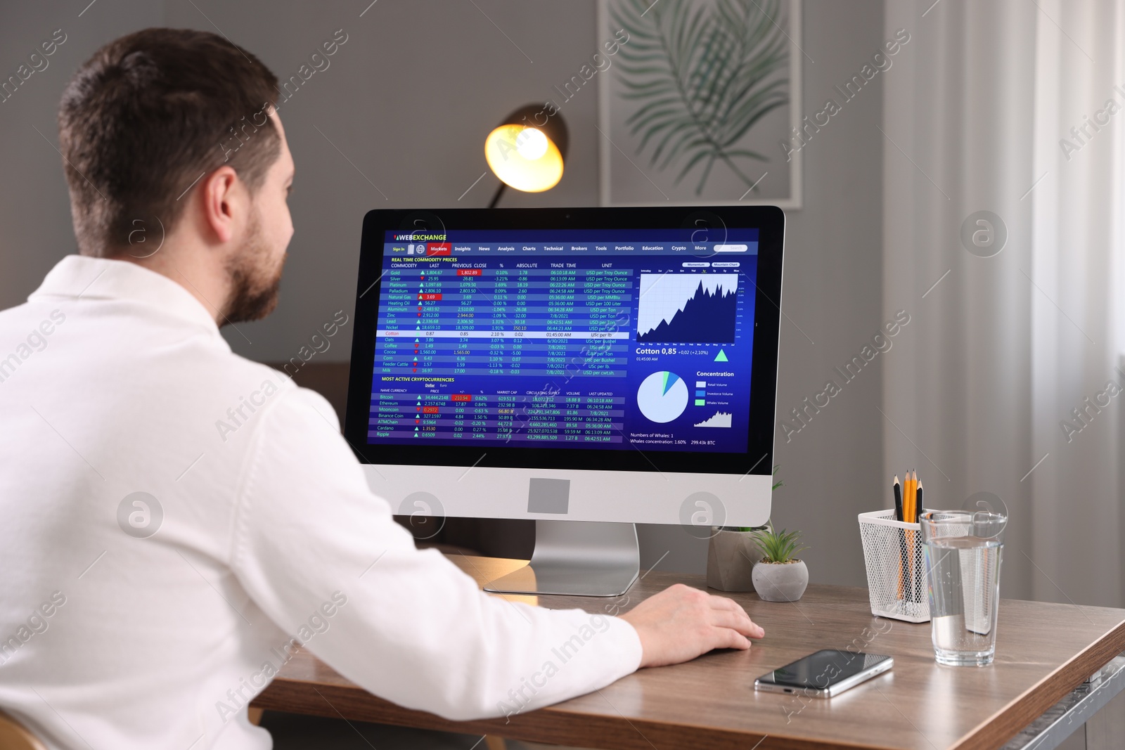 Photo of Stock exchange. Man analysing financial market on computer at desk indoors