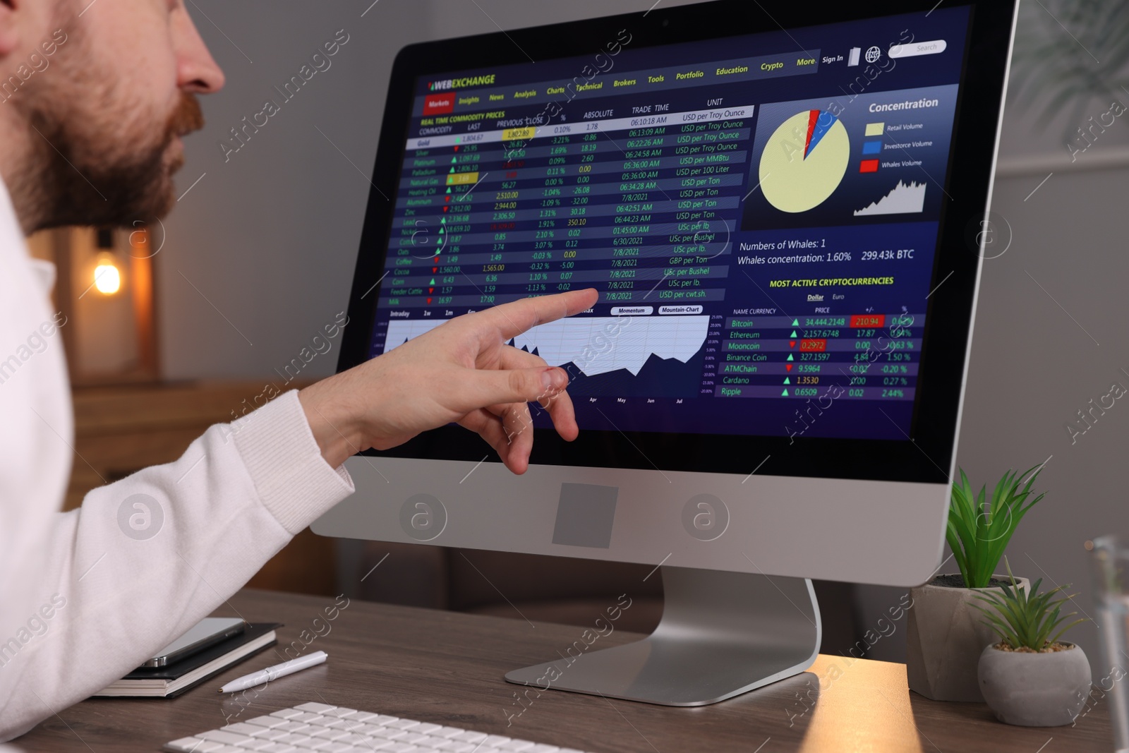 Photo of Stock exchange. Man analysing financial market on computer at desk indoors, closeup