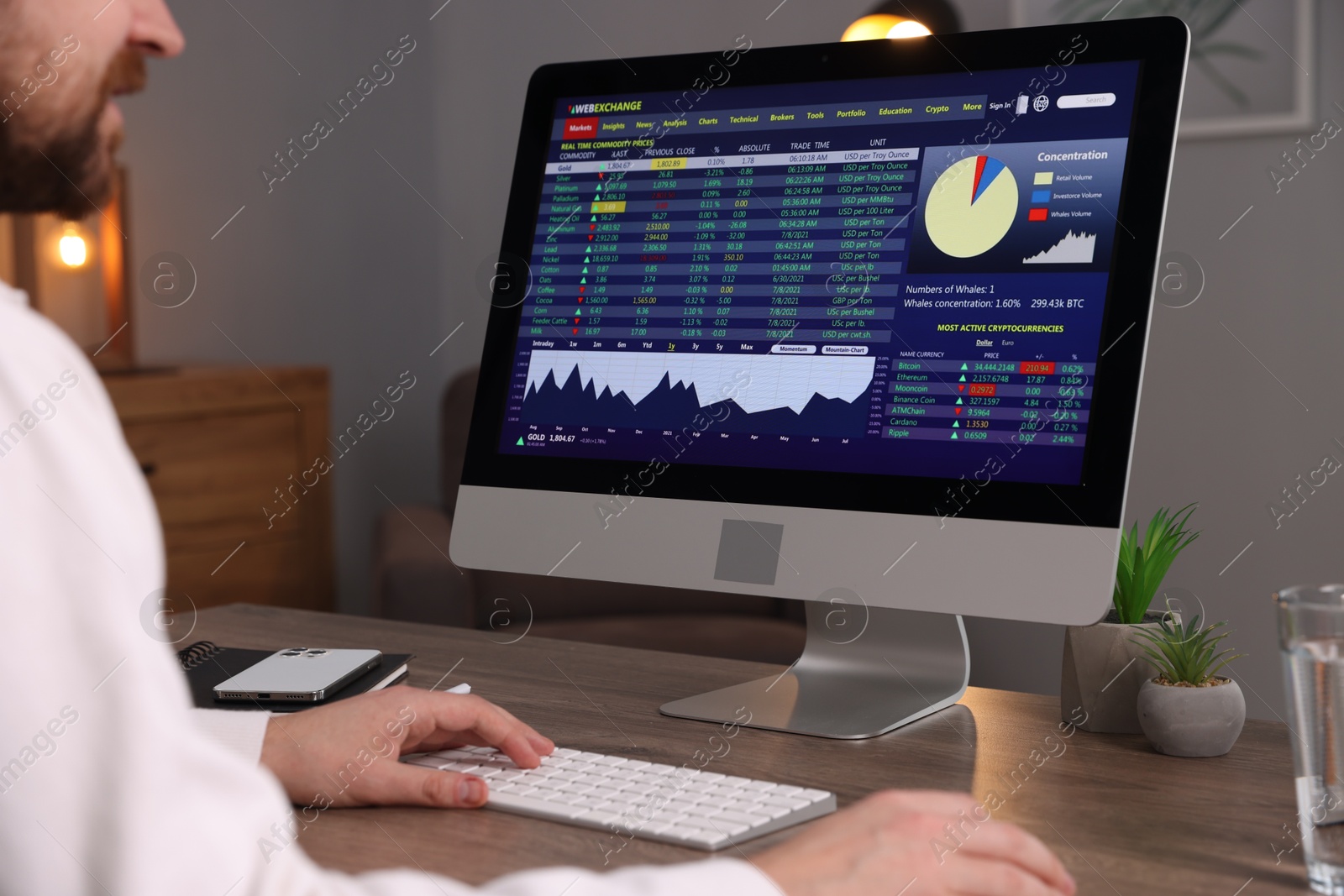 Photo of Stock exchange. Man analysing financial market on computer at desk indoors, closeup