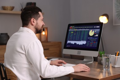 Stock exchange. Man analysing financial market on computer at desk indoors