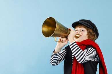 Photo of Cute boy in mime costume with megaphone on light blue background, space for text. Surprise party