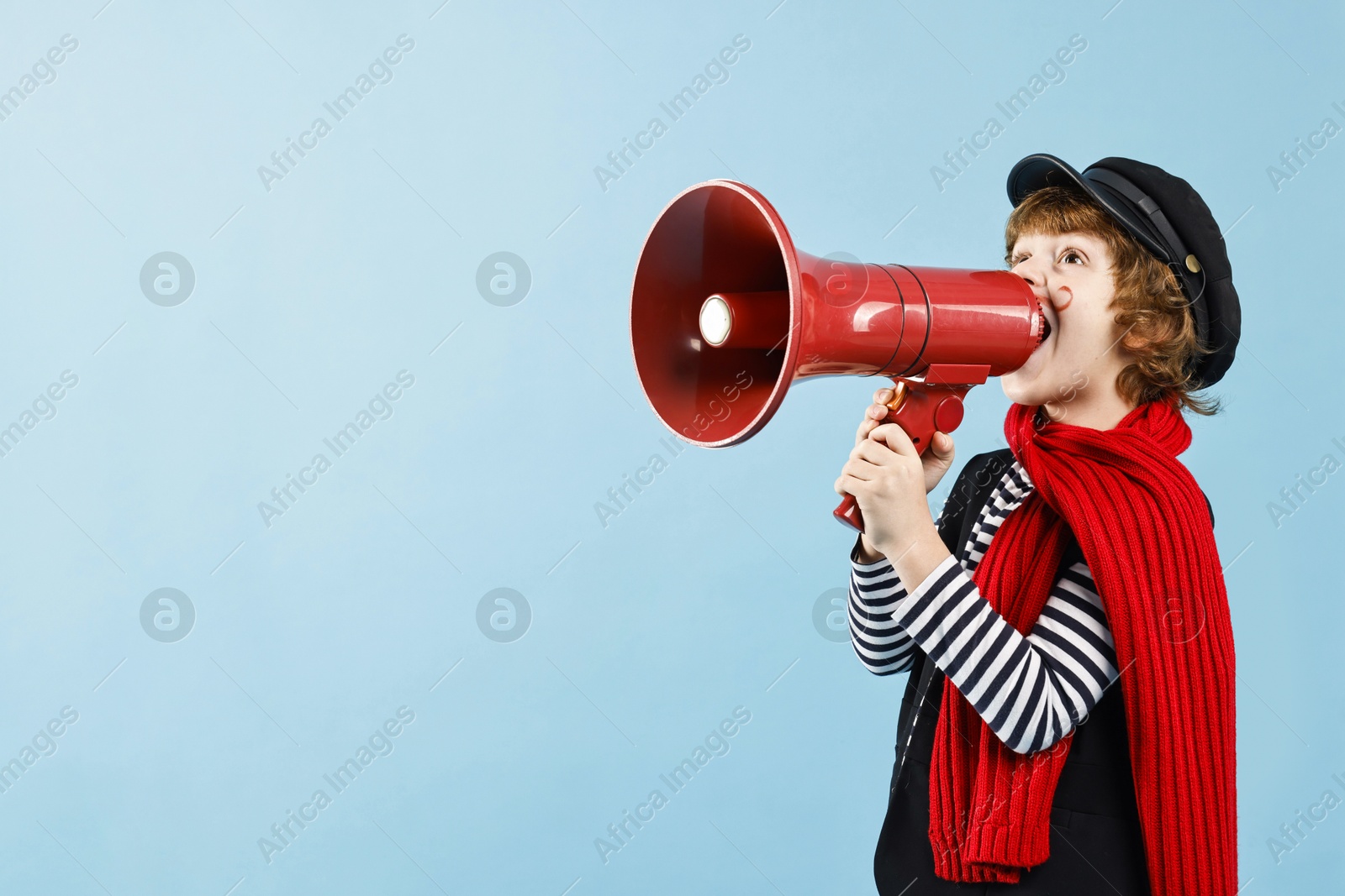 Photo of Cute boy in mime costume shouting in megaphone on light blue background, space for text. Surprise party