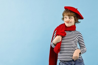 Photo of Cute boy in mime costume on light blue background, space for text. Surprise party