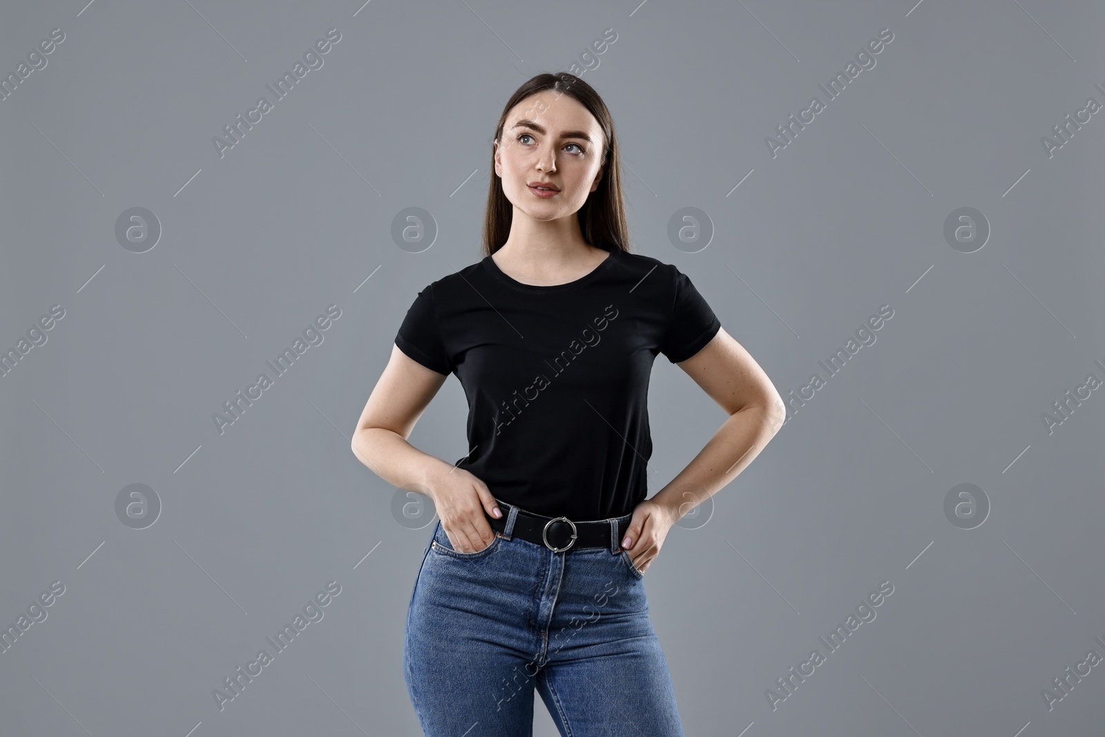 Photo of Beautiful young woman in stylish jeans on grey background