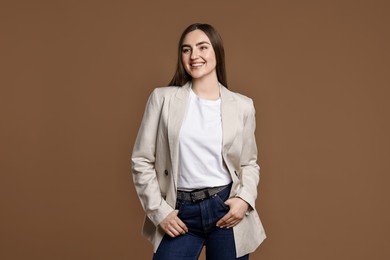 Photo of Smiling woman in stylish jeans on brown background