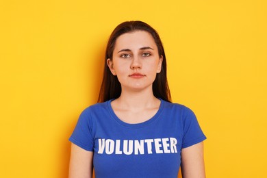 Portrait of woman in t-shirt with word Volunteer on orange background