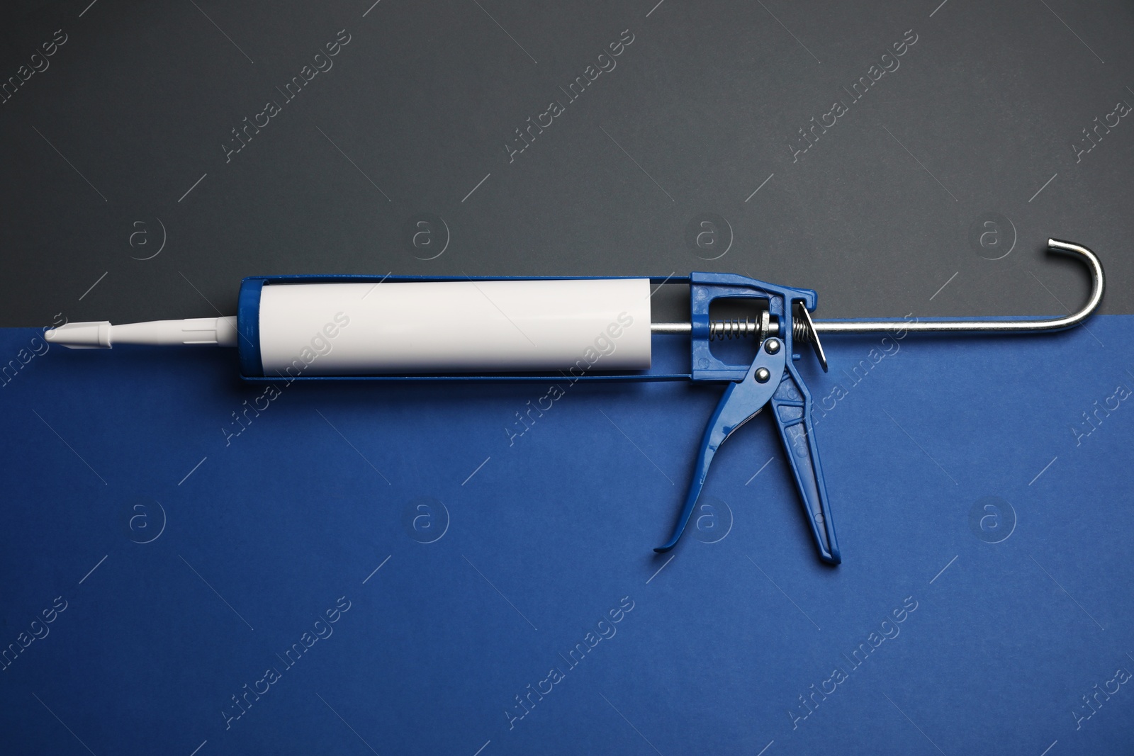 Photo of One glue gun on color background, top view