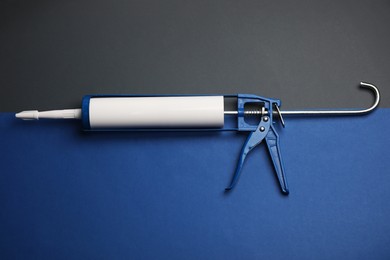 Photo of One glue gun on color background, top view