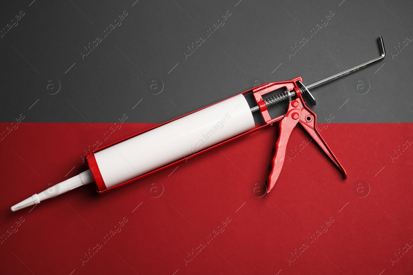 Photo of One glue gun on color background, top view