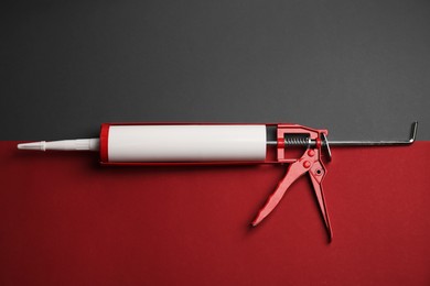 One glue gun on color background, top view