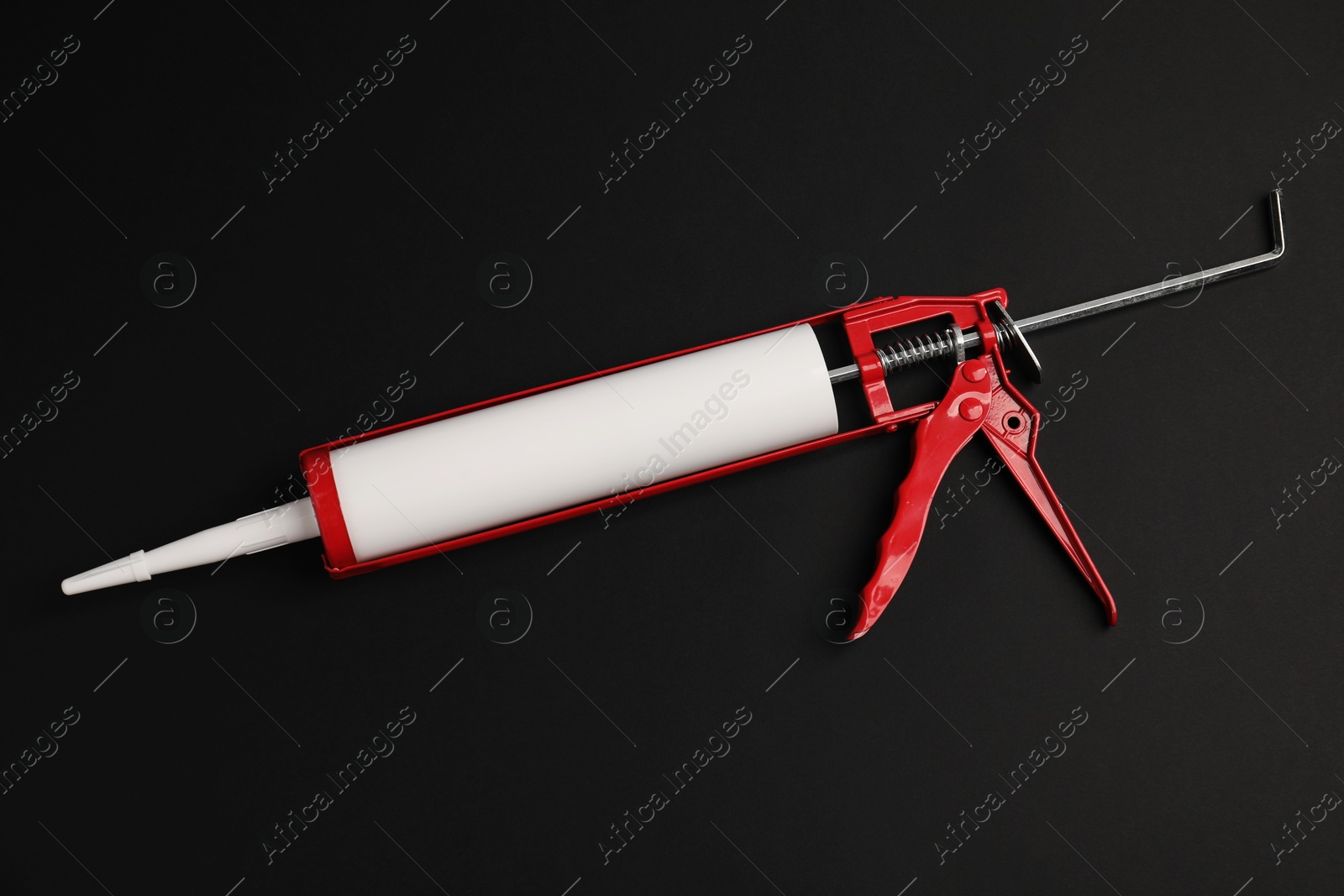 Photo of One glue gun on black background, top view