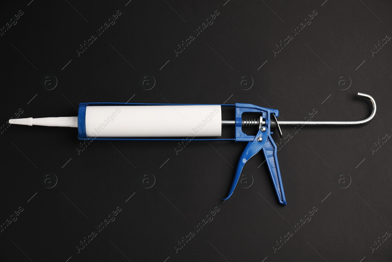 Photo of One glue gun on black background, top view