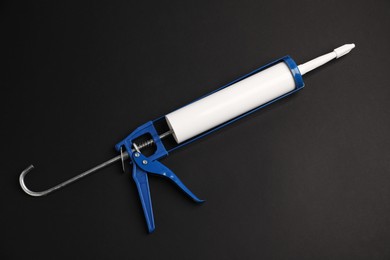 Photo of One glue gun on black background, top view