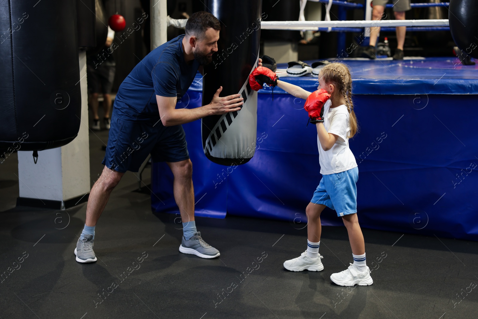 Photo of Boxing coach training girl in sport center