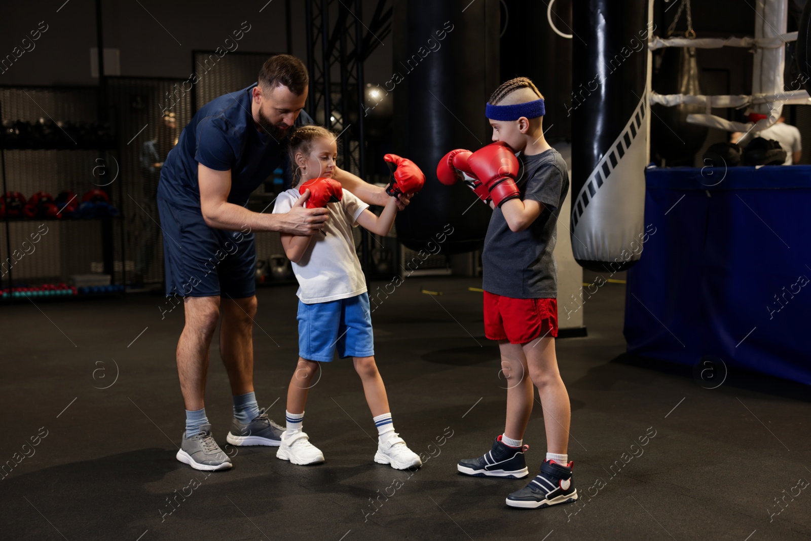 Photo of Boxing coach training children in sport center